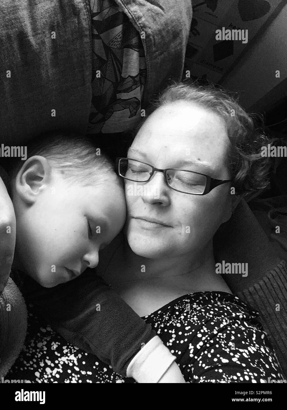 La madre e il figlio di 4 anni slumber sul divano Foto Stock