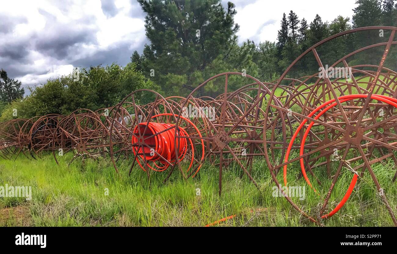 Vecchio bobine di tubo di irrigazione abbandonati sulla ferrovia a destra del titolo Foto Stock