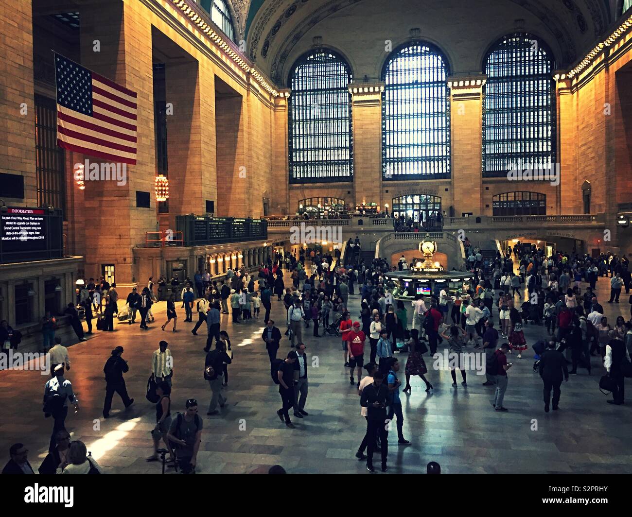 Il grand concourse all'interno del Grand Central Terminal è imballato con i viaggiatori e turisti, New York City, Stati Uniti d'America - Immagine stock catturata con smartphone