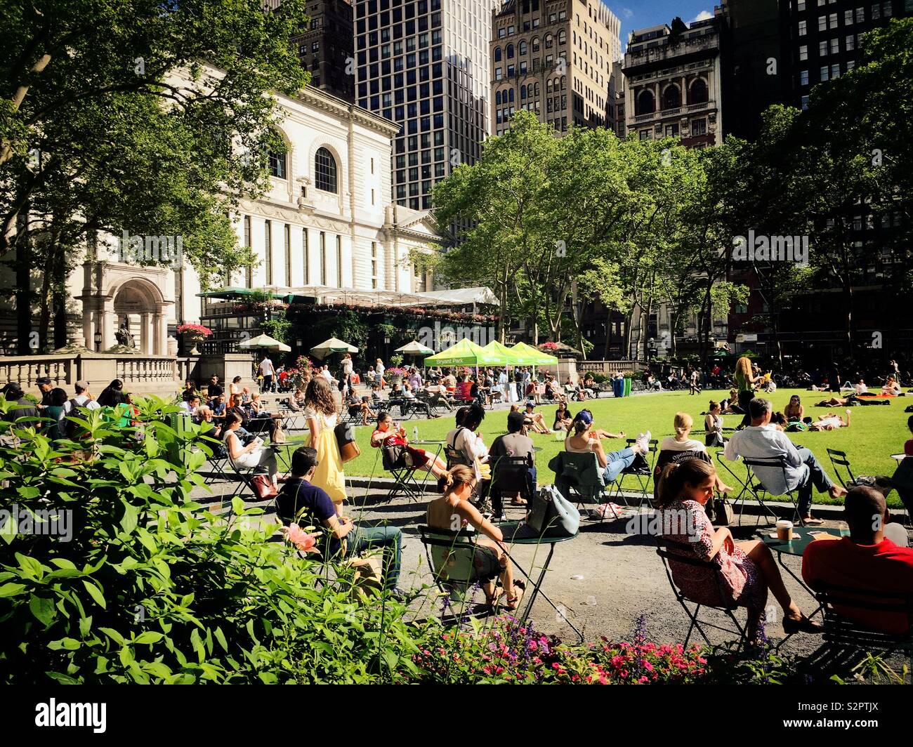 A molte persone piace il prato all'aperto e terrazza in Bryant Park dietro la biblioteca pubblica di New York, New York City, Stati Uniti d'America Foto Stock