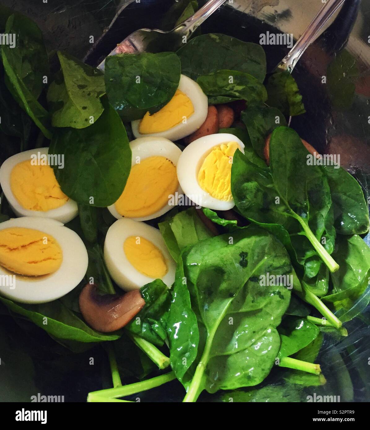 La classica insalata di spinaci con spicchi di uova sode, il bacon a pezzetti e beefy baby spinaci, dettaglio chiudere fino - Immagine stock catturata con smartphone