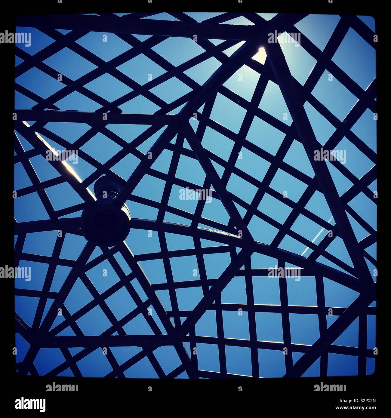Il blu del cielo visto attraverso il triangolare, a ombrello di nervature di un giardino gazebo. Foto Stock
