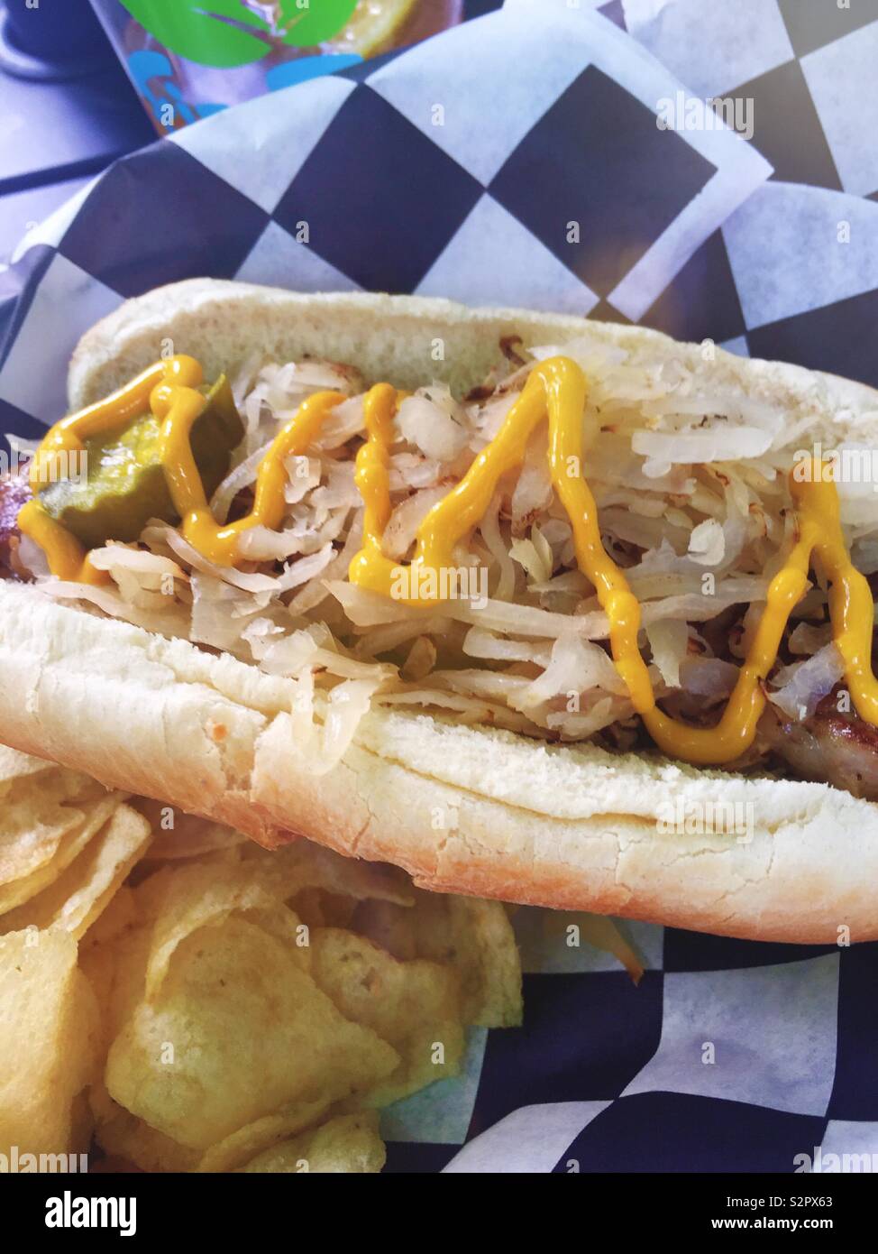 Un bratwurst con cipolle e senape è servita in un cesto in un caffè all'aperto, Stati Uniti Foto Stock