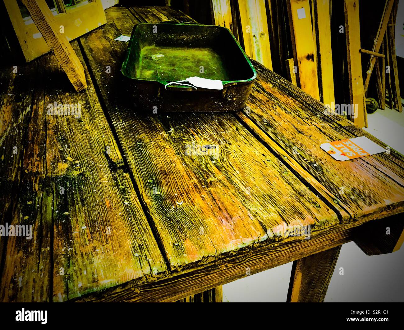 Colori esagerato in foto di rustico tavolato in legno tavolo con ghisa teglia sul visualizzatore in corrispondenza di un centro commerciale delle pulci Foto Stock