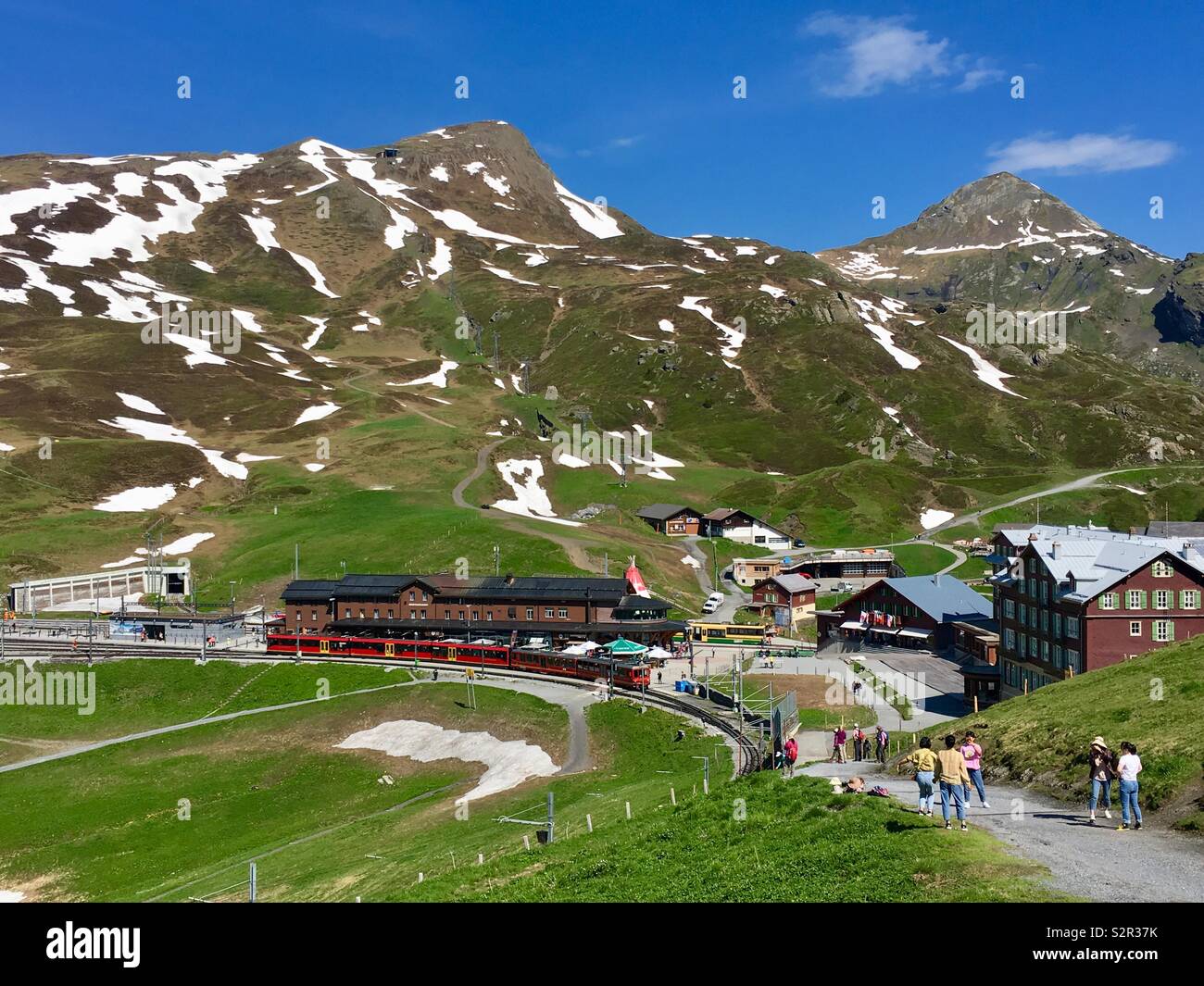 Kleine Scheidegg con la stazione ferroviaria e i turisti escursionismo. La primavera, Grindelwald, alpi Bernesi, Svizzera. Foto Stock
