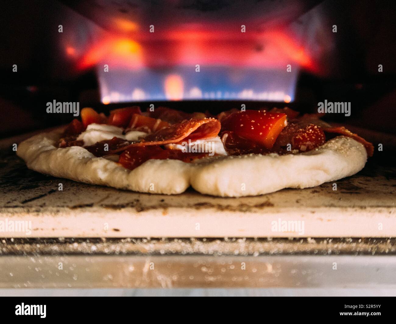 La cottura della pizza in un gas di forno per pizza - Immagine stock catturata con smartphone