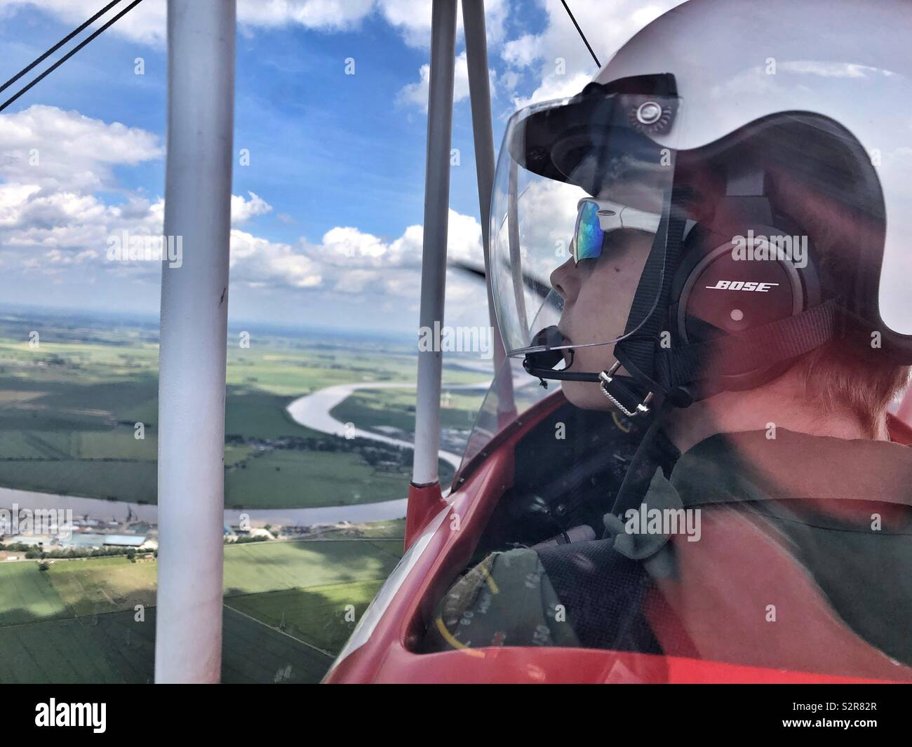 Pilota di un biplano rosso battenti dal fiume di Trento Foto Stock