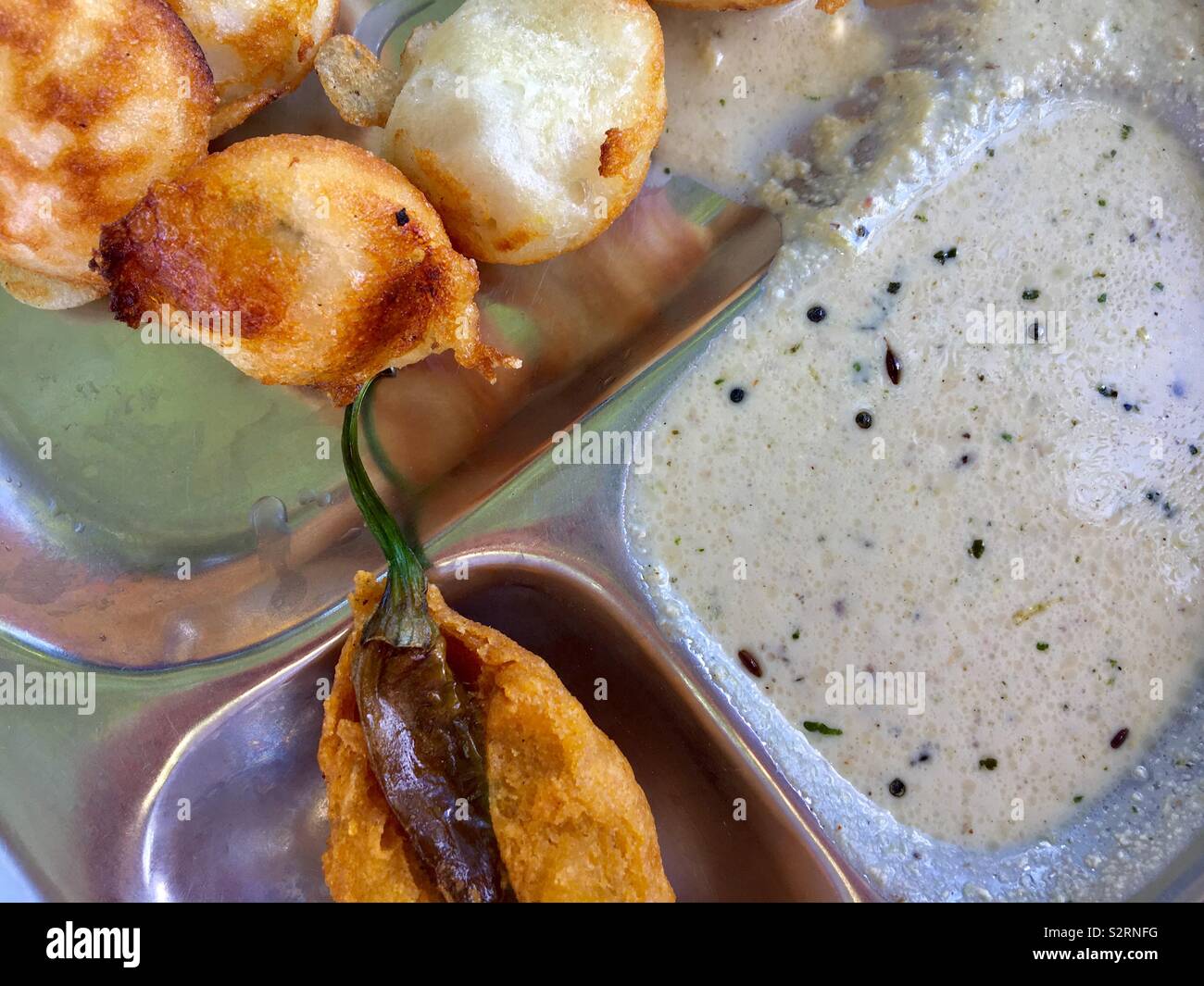 In prossimità di alcuni Pudu, chutney e fritte al peperoncino su una classica indiana piastra thali Foto Stock