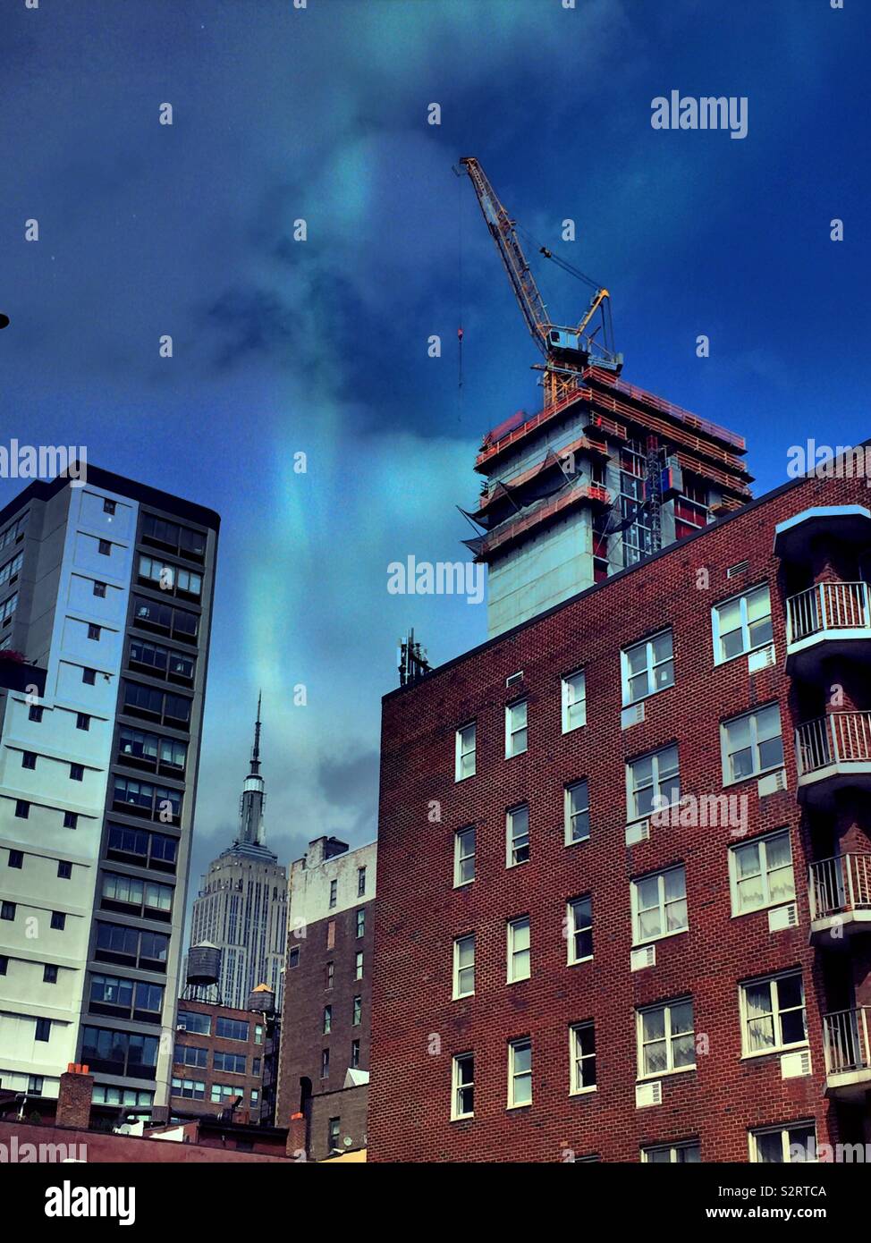 Una serata street scene in Chelsea con l'Empire State building e alto edificio di costruzione, NYC, STATI UNITI D'AMERICA - Immagine stock catturata con smartphone