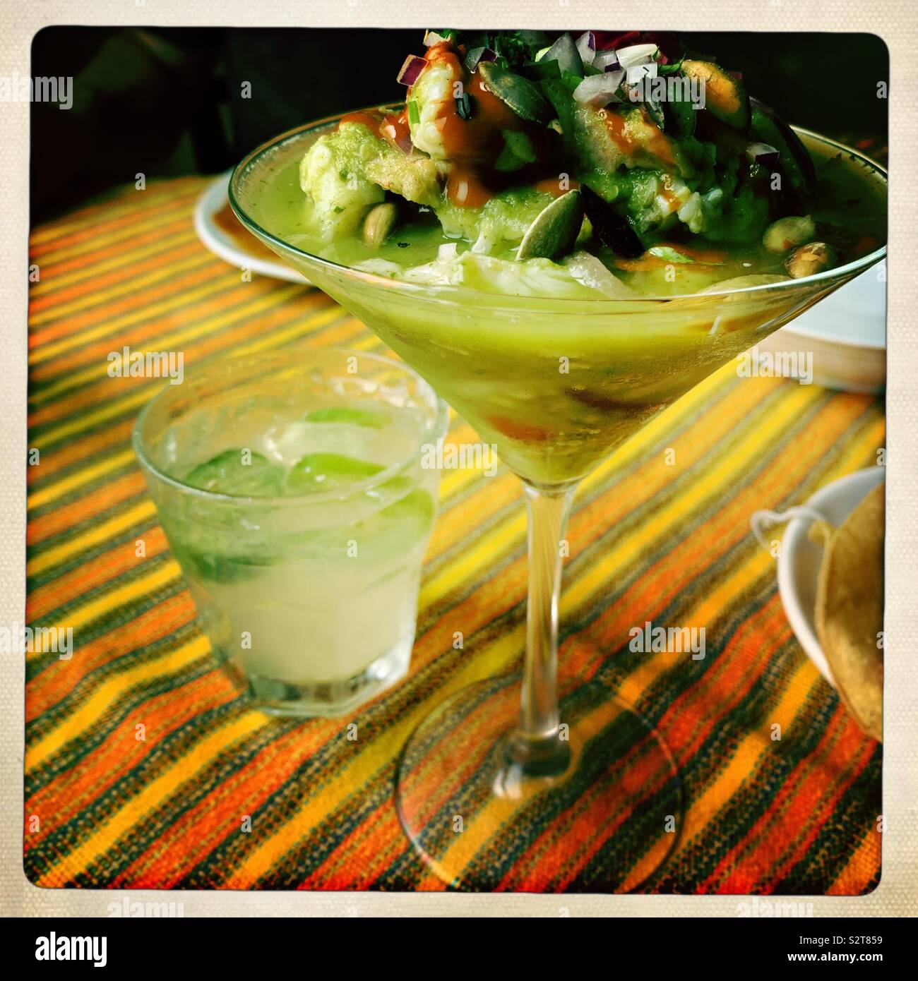Ceviche di gamberi servito in bicchiere di martini con cocktail di margarita al ristorante messicano - Immagine stock catturata con smartphone