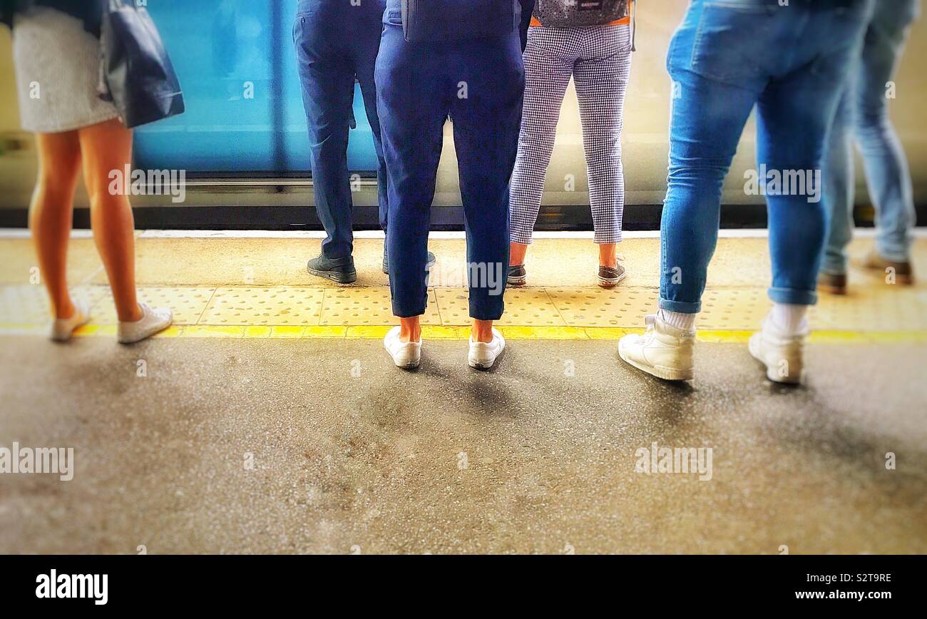 Di passeggeri su una piattaforma in corrispondenza di una stazione ferroviaria in attesa di salire a bordo di un treno che è appena arrivato. I passeggeri sono casualmente vestito come è in un caldo giorno d'estate. Foto Stock