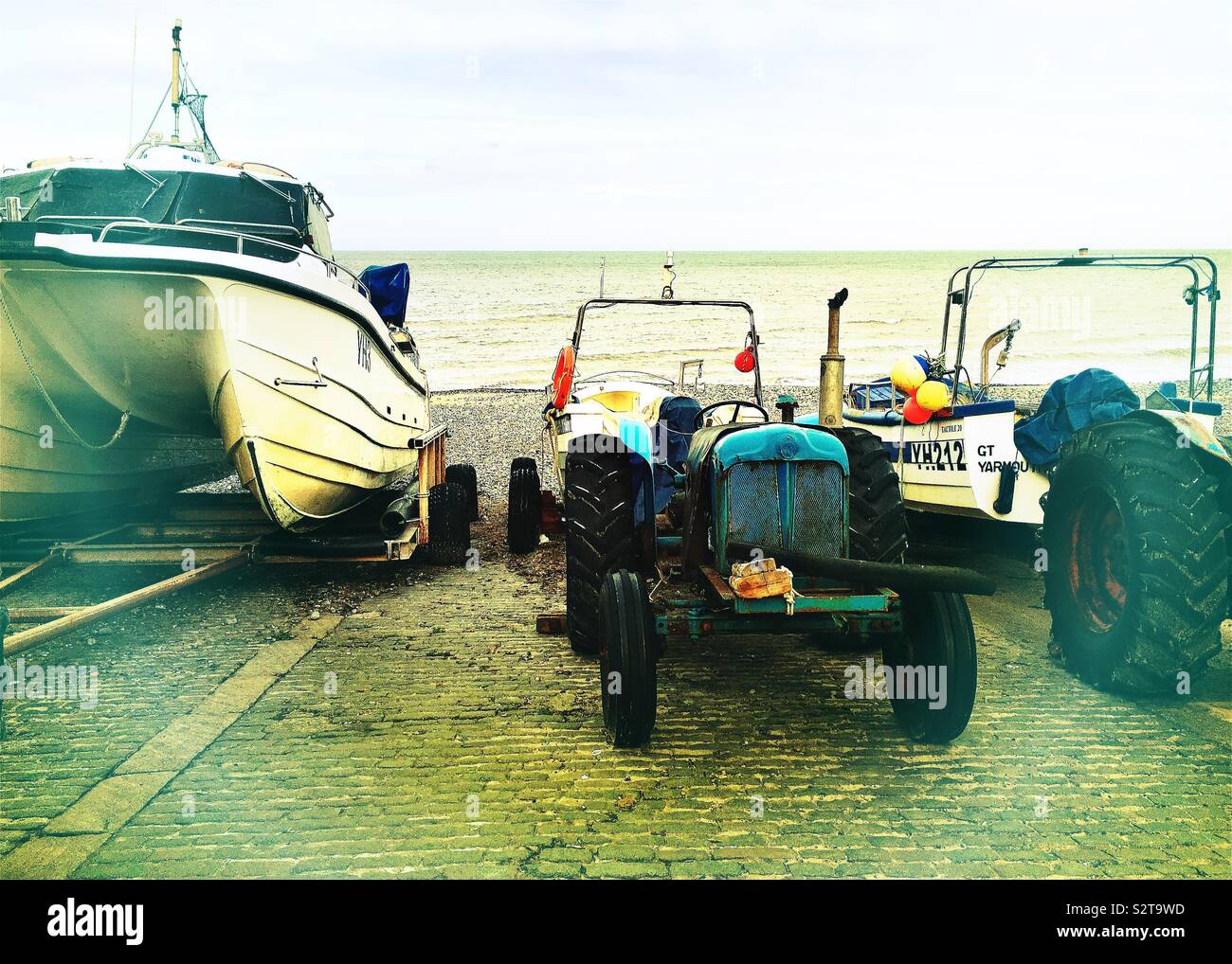 Barche e il trattore su Cromer Beach Foto Stock