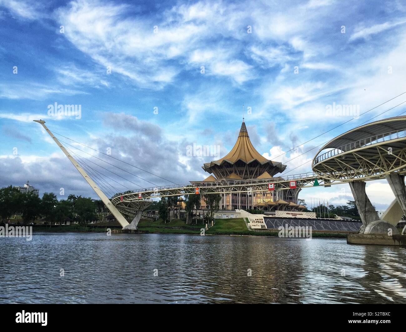 La Darul Hana Bridge consente ai pedoni di attraversare il fiume Sarawak dal lungomare precinct per l Assemblea Legislativa dello Stato Edificio, Kuching, Sarawak, Malaysia - Immagine stock catturata con smartphone