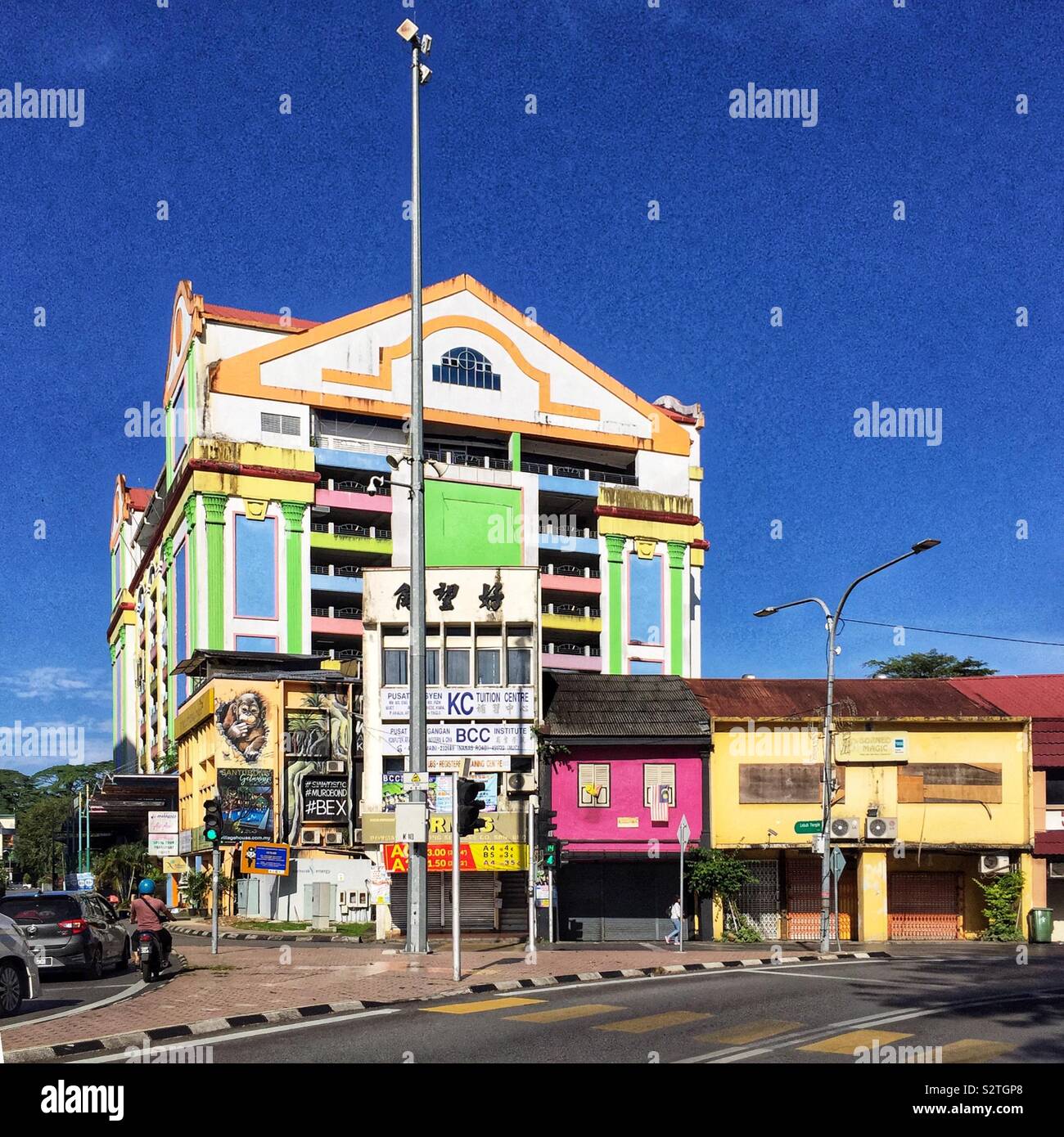 Jalan Bazaar Principale con il colorato a più piani per il parcheggio che i servizi Waterfront Bazaar, il centro storico della città sulla riva sud del fiume Sarawak Kuching, Sarawak, Malaysia - Immagine stock catturata con smartphone
