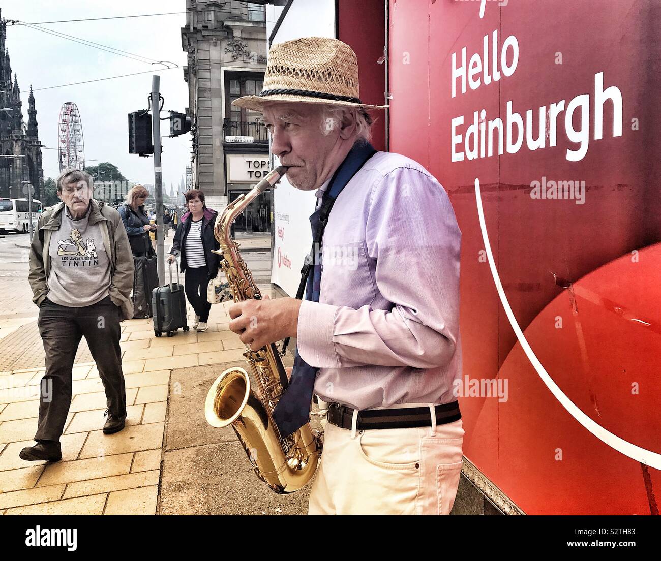 Ciao Edinburgh - un fresco Alto Sax player intrattiene la gente su Princes Street, Edimburgo, Scozia, Regno Unito. Foto Stock