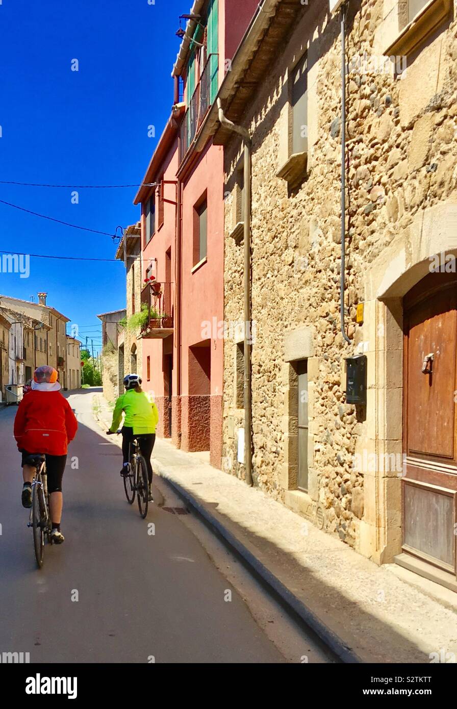 Due ciclisti femmina a cavallo del villaggio a Monells provincia di Girona Catalogna Spagna Foto Stock