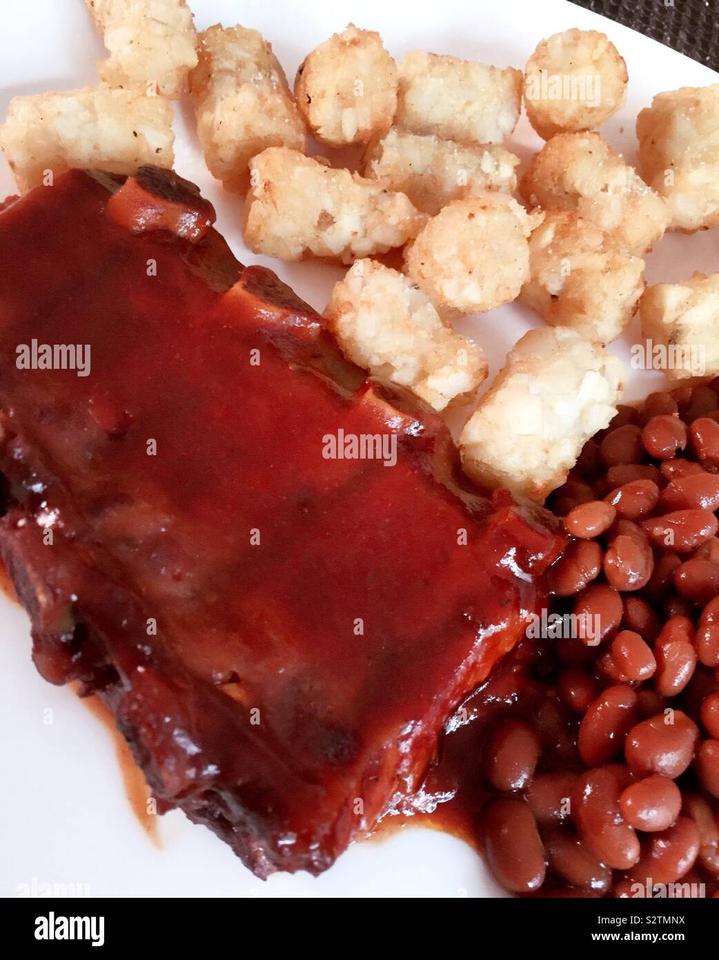 Classic down-home American pasto della brace spareribs, fagioli al forno e premnoplex tots, STATI UNITI D'AMERICA - Immagine stock catturata con smartphone
