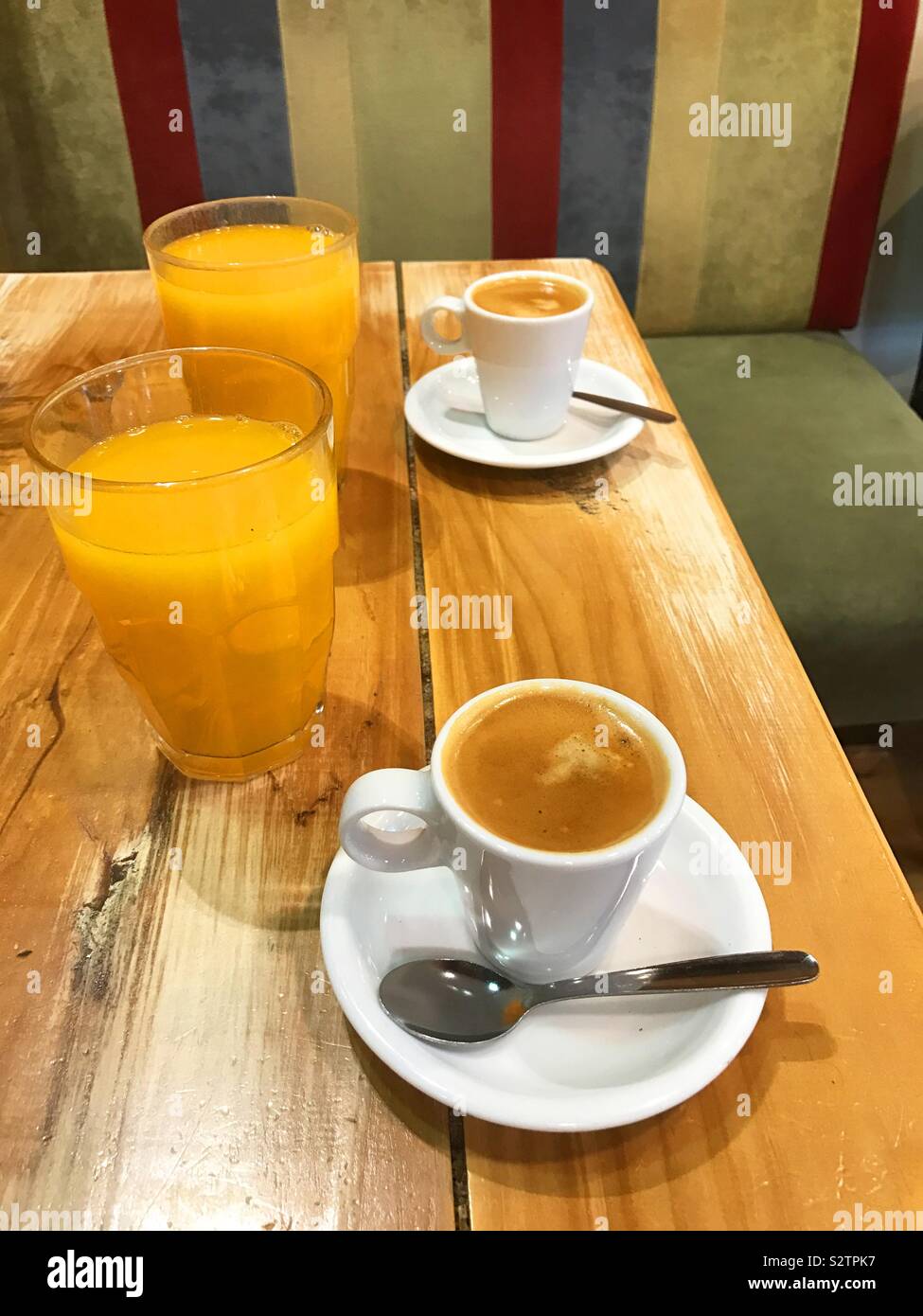Due tazze di caffè e due bicchieri di succo di arancia. Foto Stock