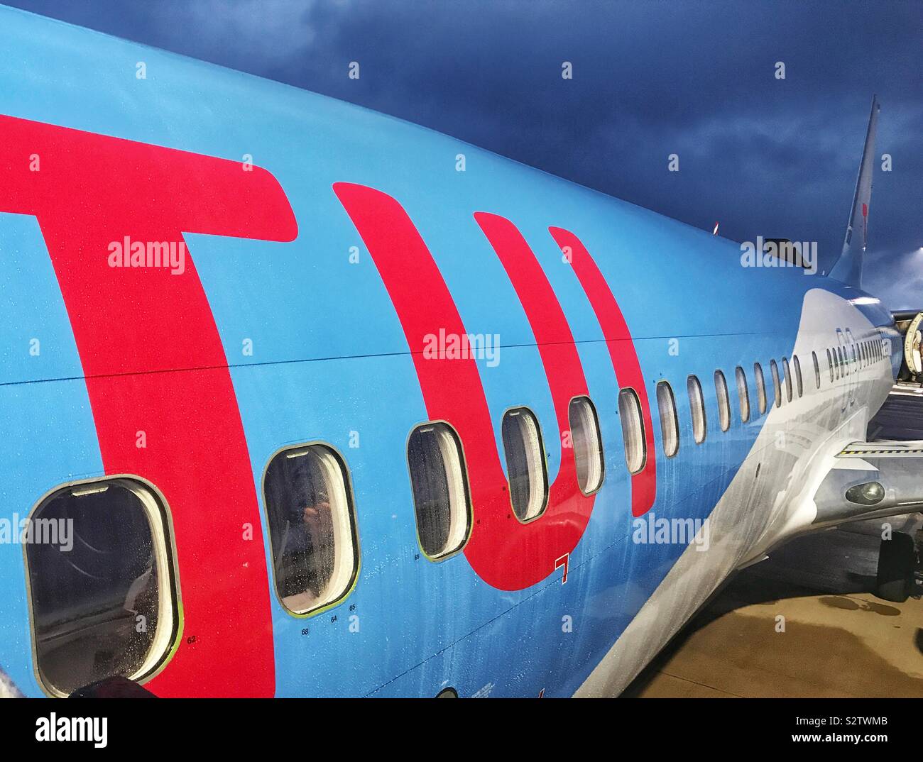 TUI logo sul lato di un getto di vacanze di prima mattina con nuvole di tempesta Foto Stock