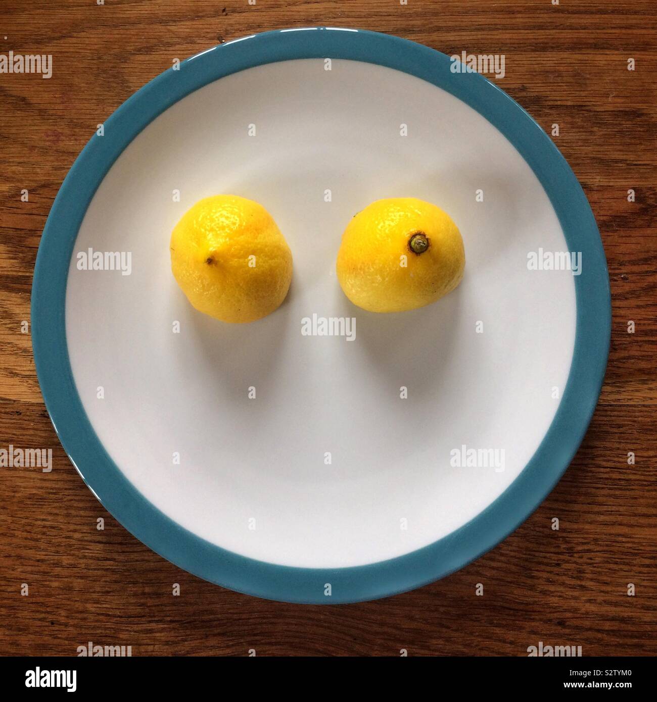 Tagliare il limone su una piastra - guardando come occhi o tette - Pareidolia Foto Stock