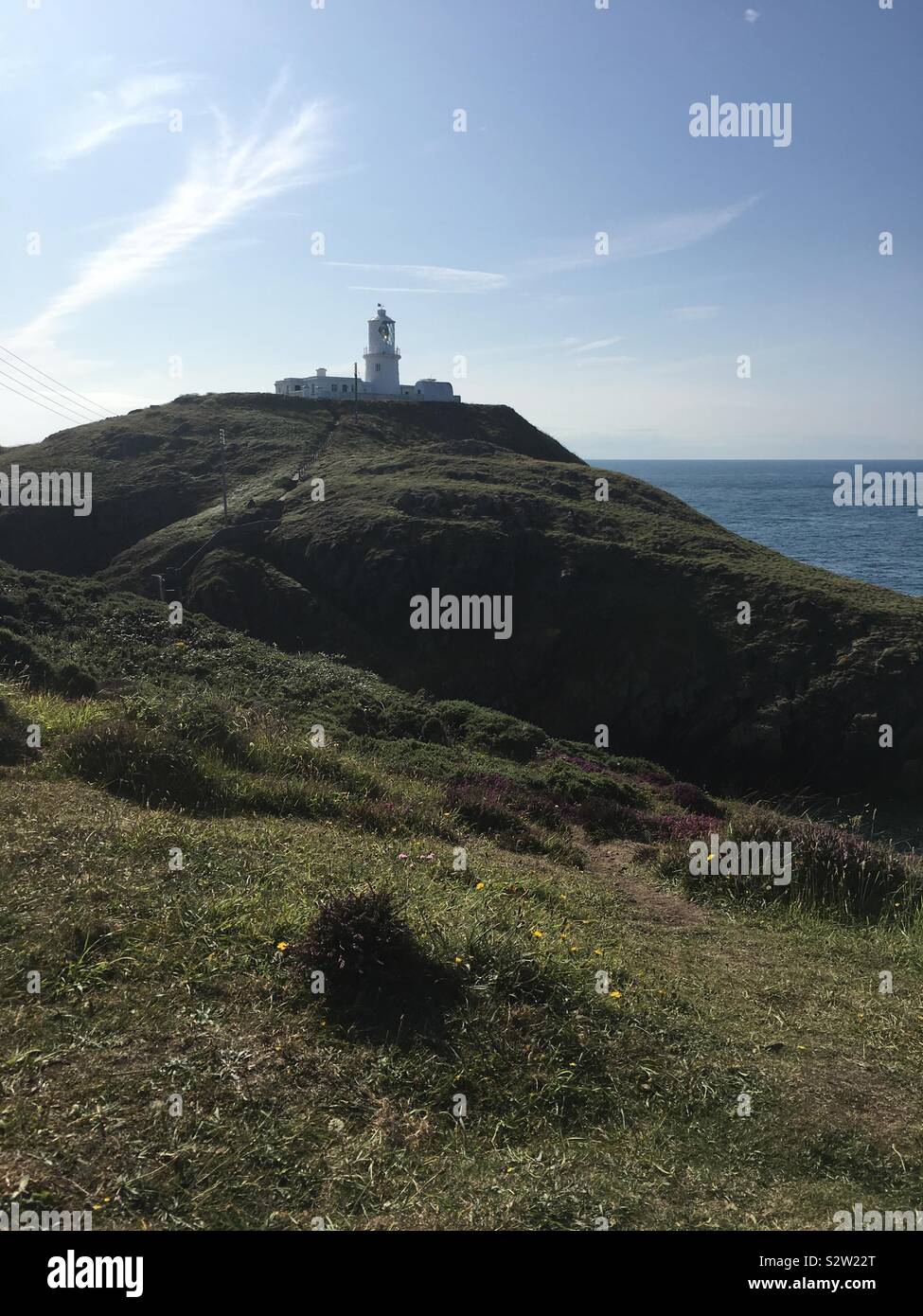 Strumble Head Lighthouse con il mare sullo sfondo. Pembrokeshire, West Wales, Regno Unito Foto Stock