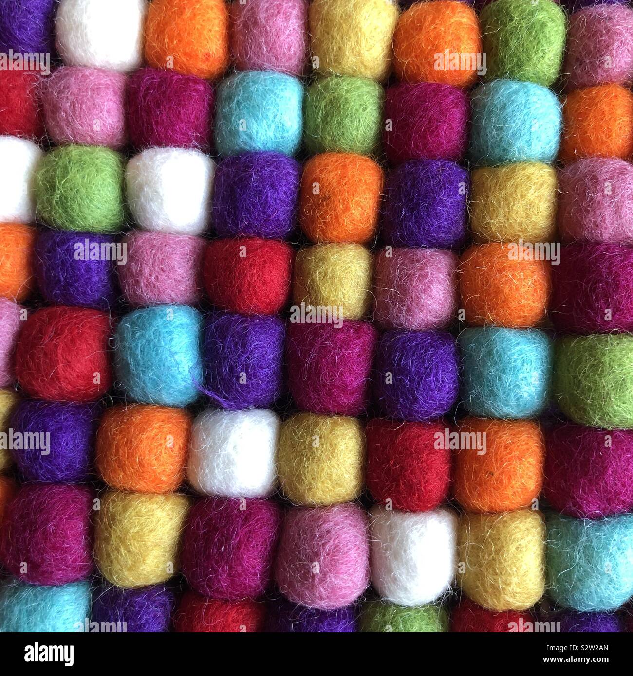 Un primo piano di molti colorata lana sfere allineate in righe e colonne Foto Stock
