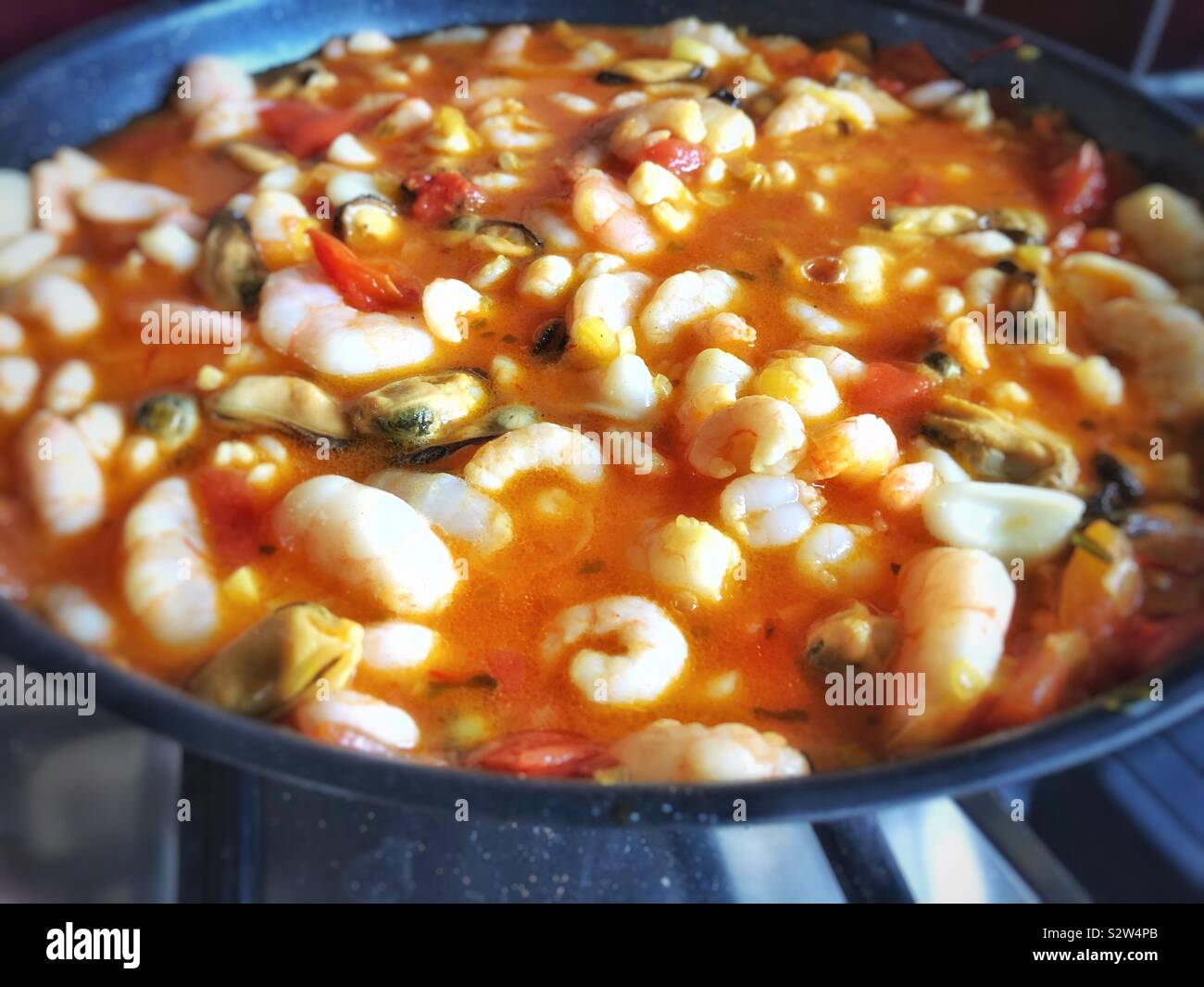 Frutti di mare in Saffron, aglio vermouth e salsa di pomodoro. Foto Stock