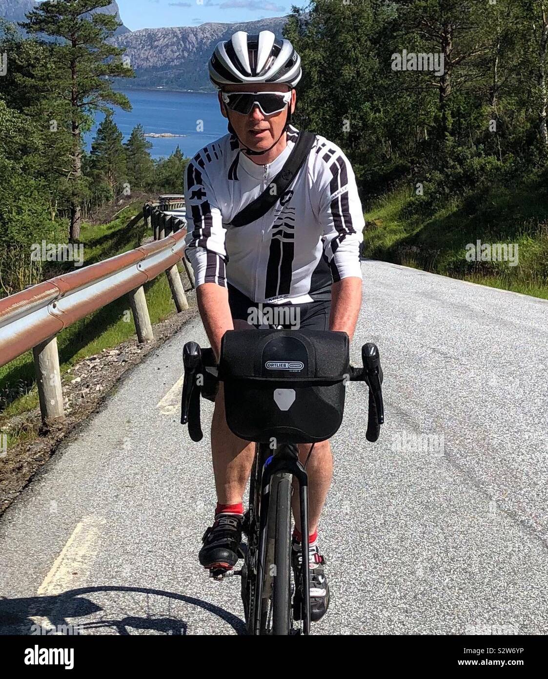 Ciclista maschio in sella in salita nei pressi di Sognefjord, Norvegia. Foto Stock