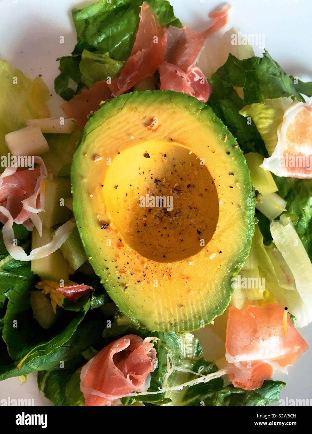 Piatto dettaglio laici di una metà di avocado su una fresca insalata estiva Foto Stock