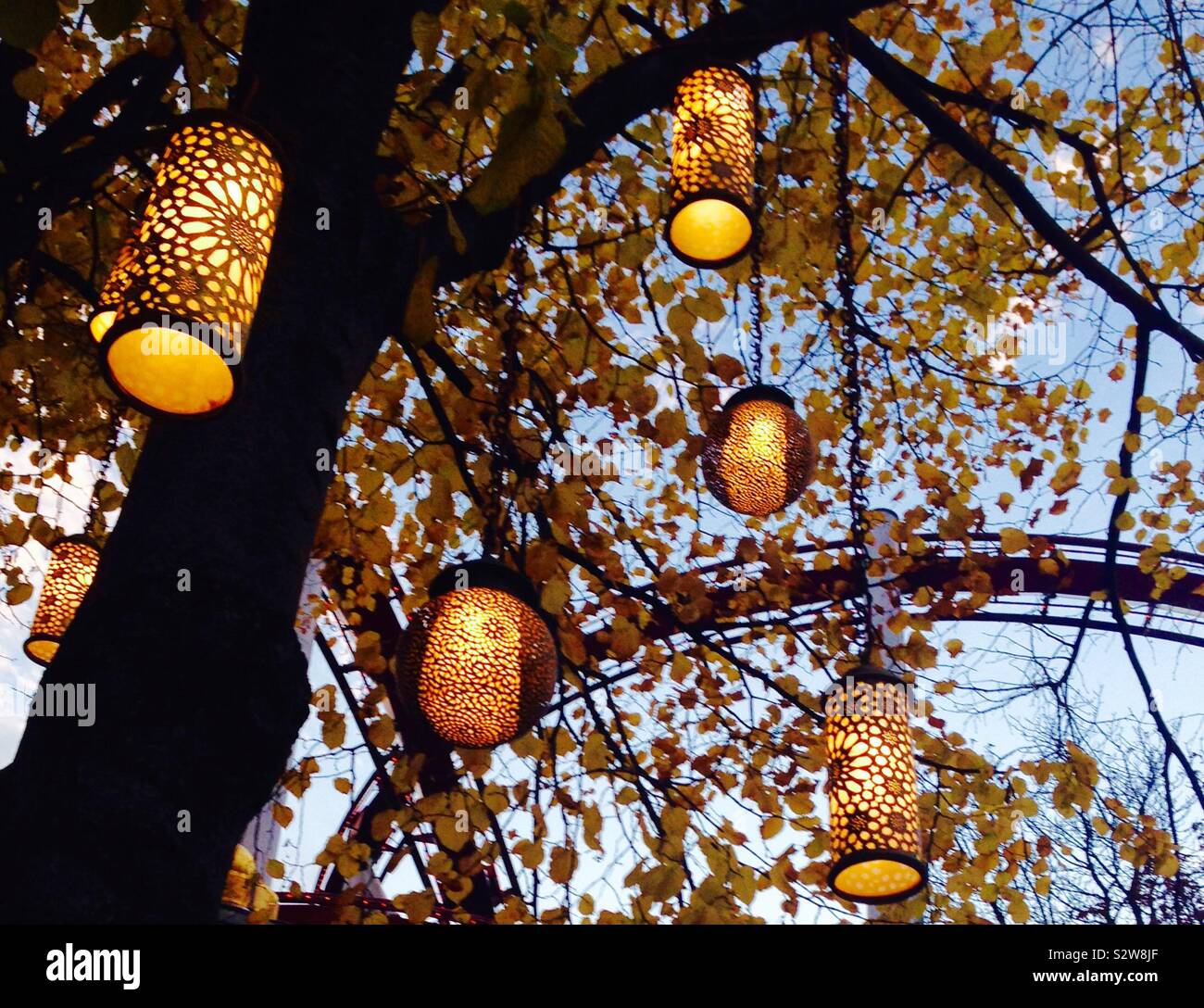 Fairytale lanterne pendenti da alberi e illuminare il parco. Preso in giardini di Tivoli, København - Copenhagen, Danimarca Foto Stock