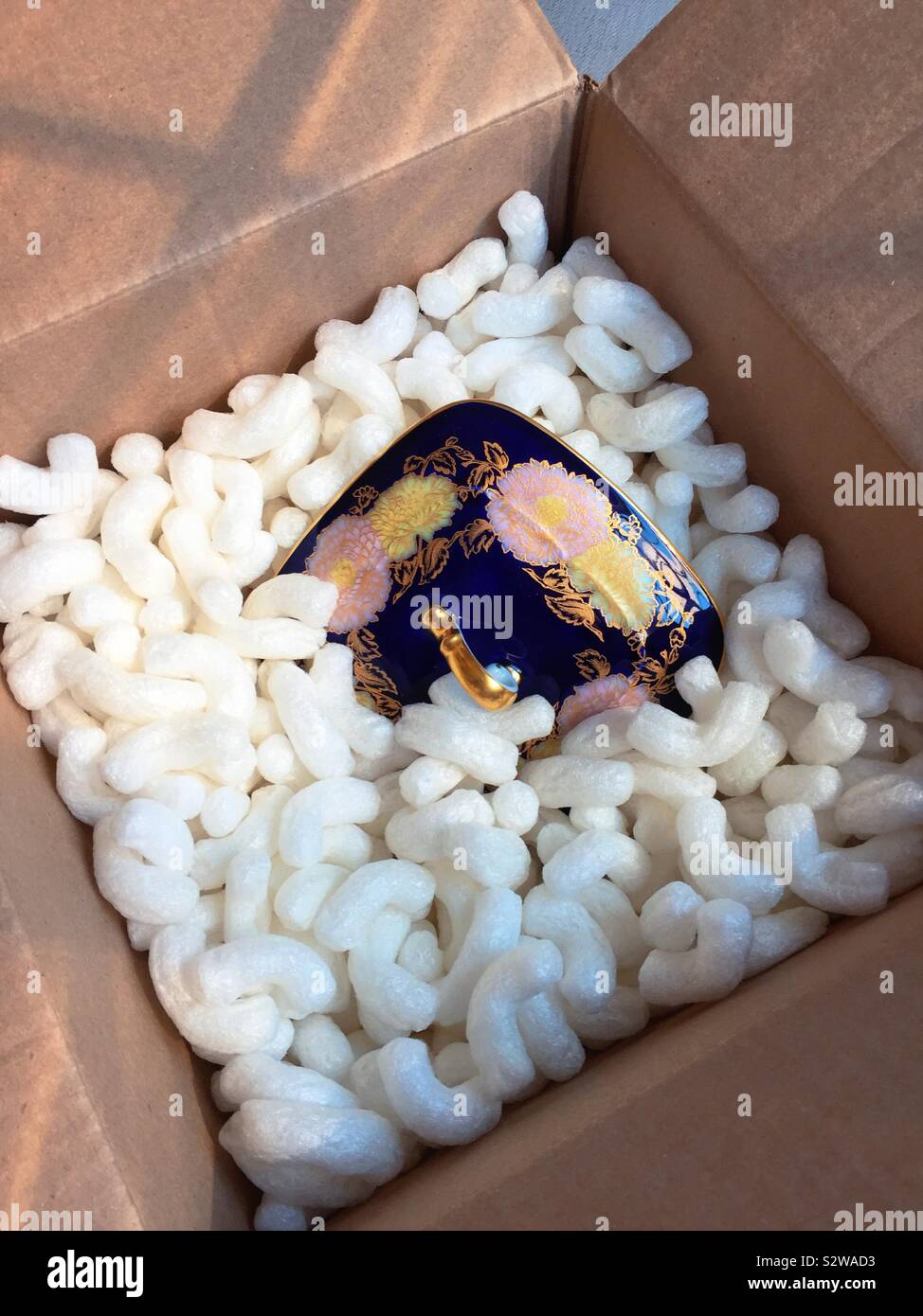 Fragile cina piatto da portata in un cartone confezione circondato da noccioline di polistirolo - Immagine stock catturata con smartphone