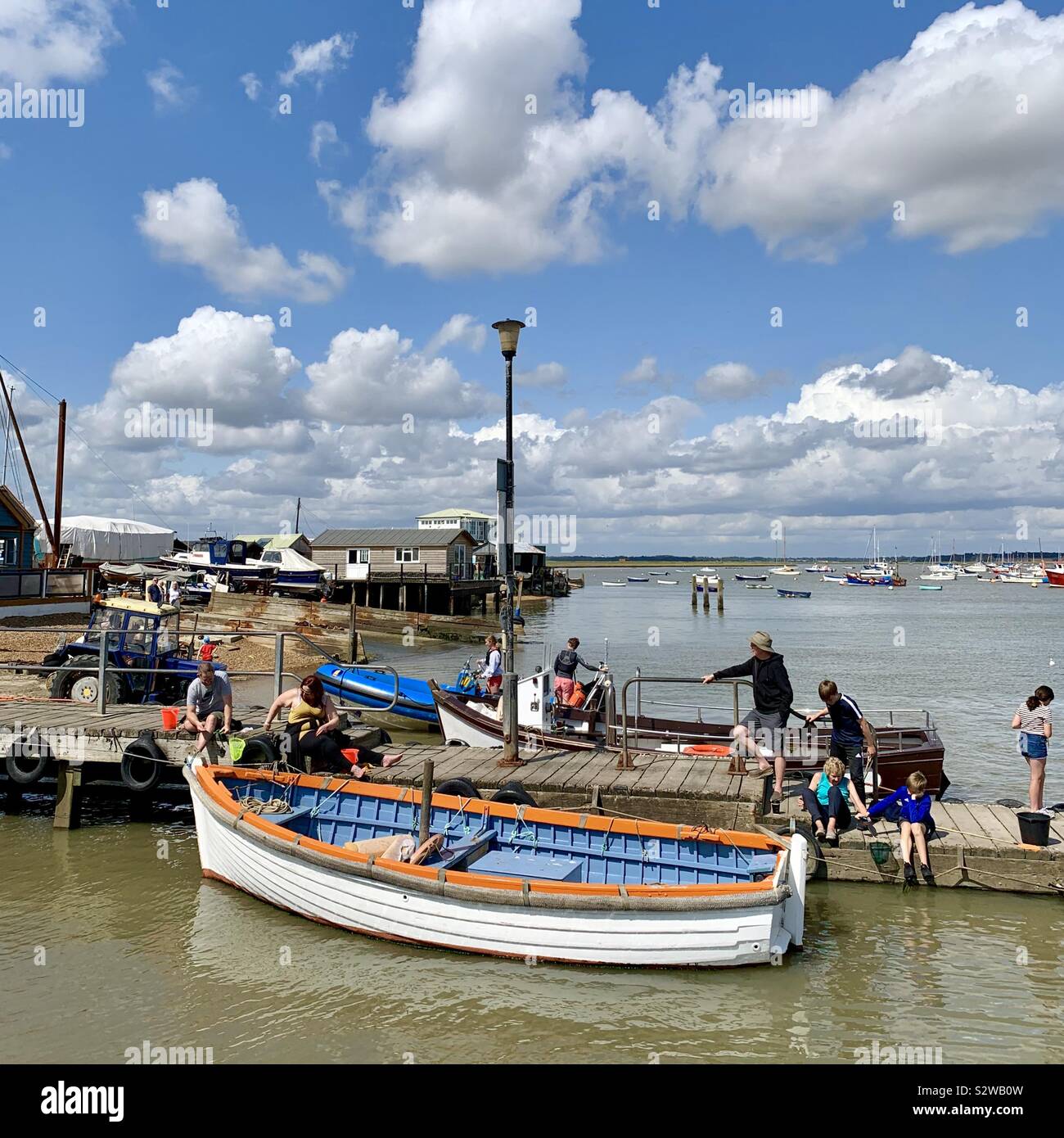 Felixstowe Ferry, Suffolk, Regno Unito - 19 August 2019: persone attività di pesca del granchio dal molo sul Fiume Deben. Foto Stock