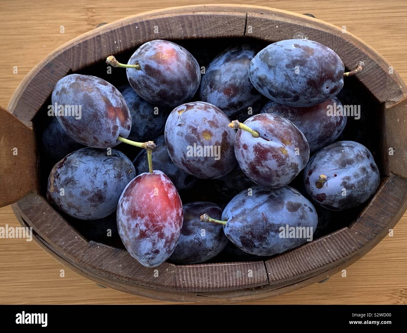 Mature heap di prugne in una scatola di legno - Immagine stock catturata con smartphone