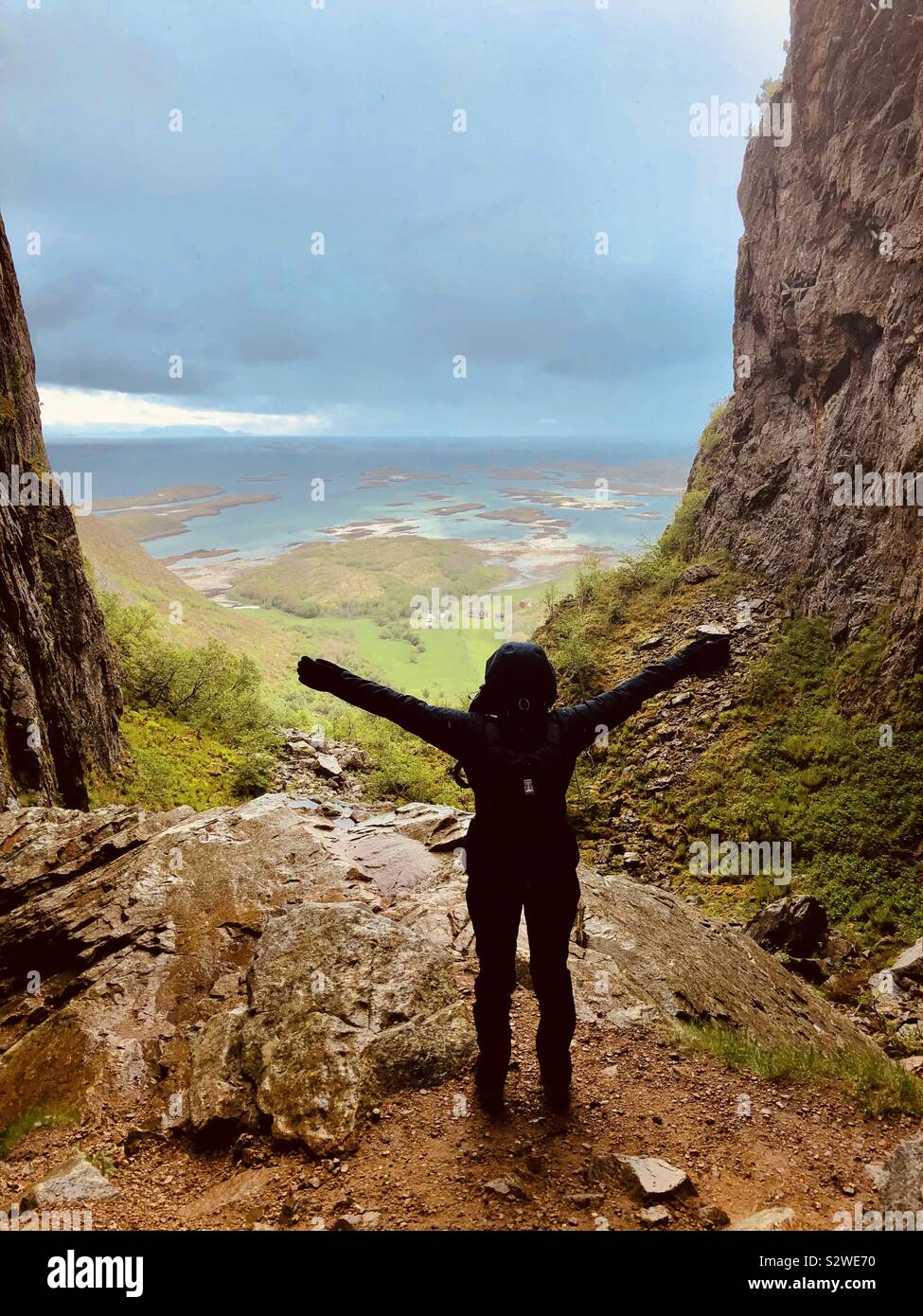 Donna che abbraccia il paesaggio, Torghatten grotta, Norvegia Foto Stock