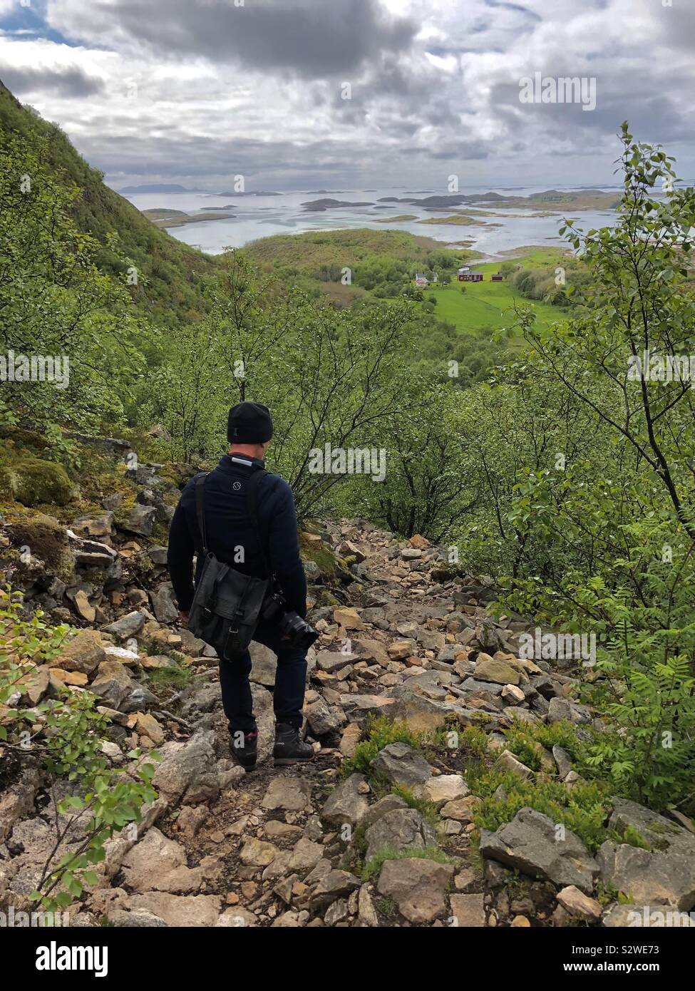 Uomo che cammina giù la via dalla grotta Torghatten, Norvegia Foto Stock