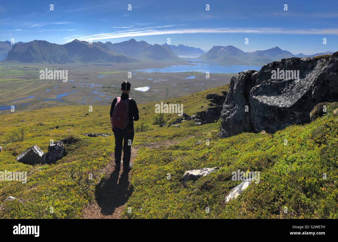 Uomo che cammina sul Monte Hoven, Gimsoya, Isole Lofoten in Norvegia Foto Stock