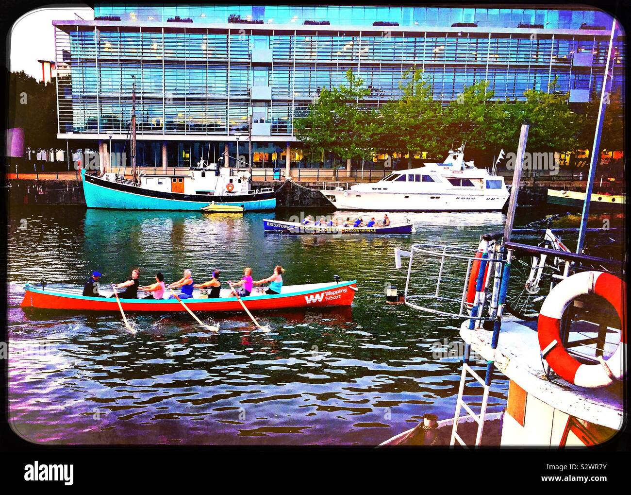 Donne remare una barca nel porto di Bristol Foto Stock