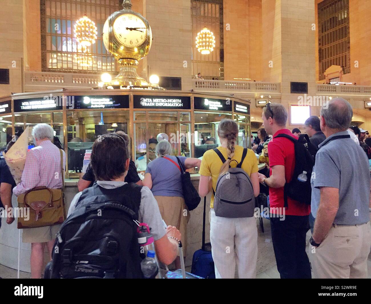 Taurus lineup presso il chiosco informazioni nella grand concourse al Grand Central Terminal di porre domande del personale, NYC, STATI UNITI D'AMERICA - Immagine stock catturata con smartphone
