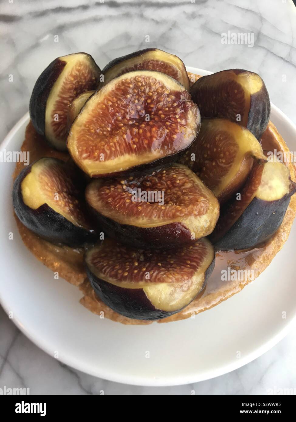 Foto di succosa e deliziosa fig tart contro un tavolo di marmo di sfondo Foto Stock