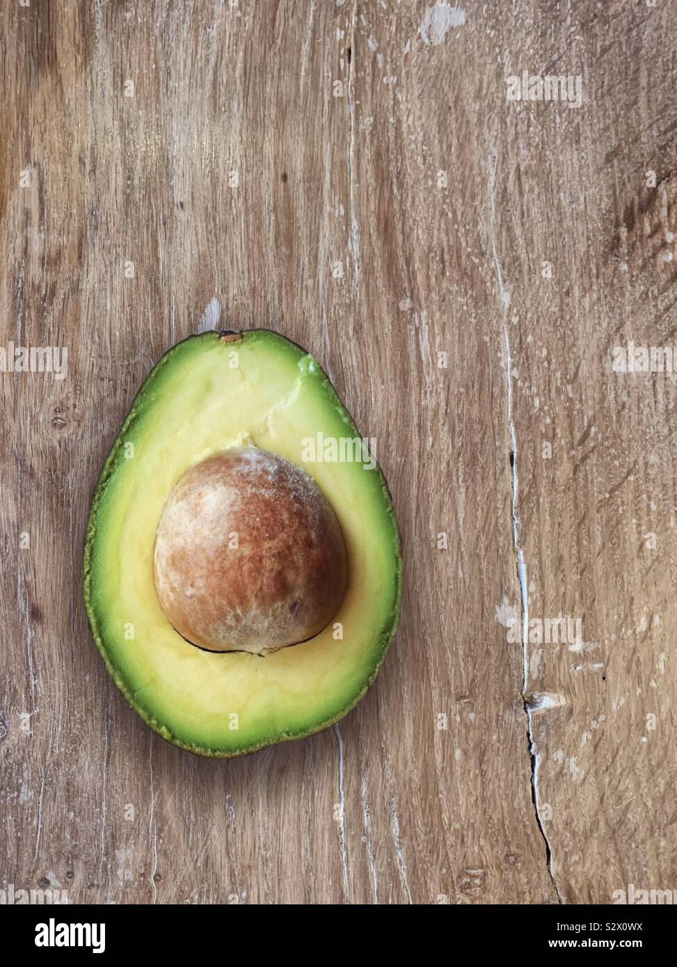 Avacado metà su un tavolo di legno Foto Stock