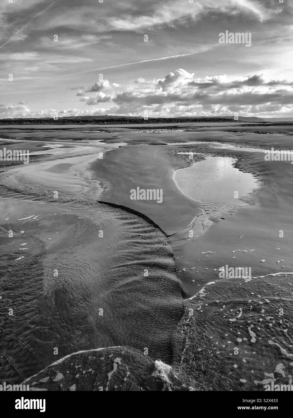 Piccoli rivoli di acqua il drenaggio di sabbia nel mare. Foto Stock