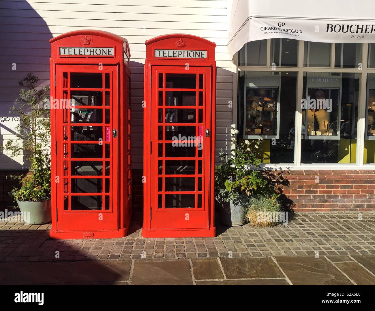 Cabine telefoniche rosse presso il Villaggio di Bicester - una volta di proprietà di British Telecom e un simbolo di britannicità. Foto Stock