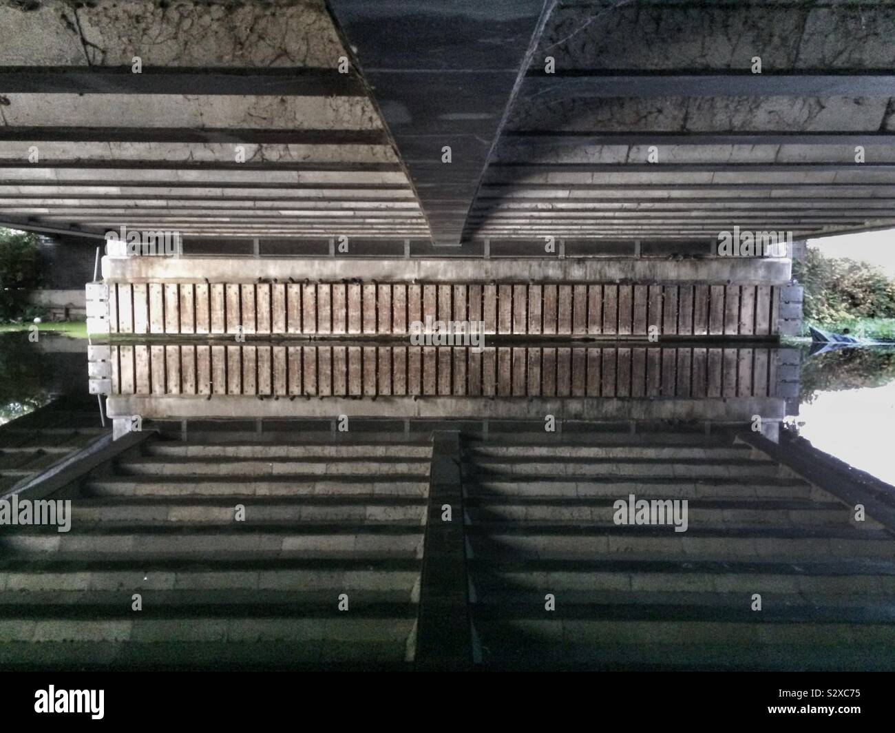 La riflessione di un ponte che va su un canale, la creazione di un quasi immagine simmetrica Foto Stock