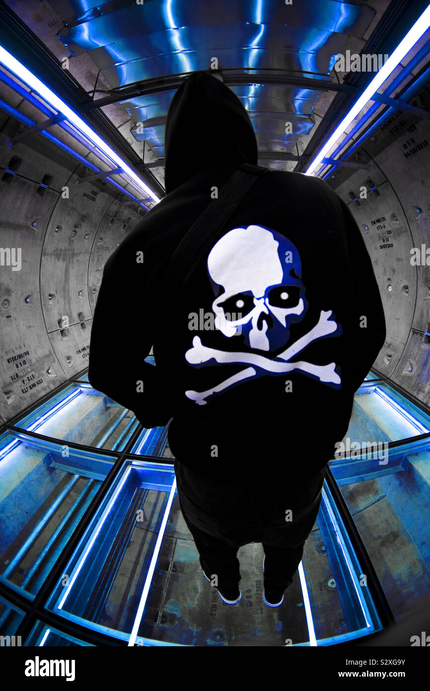 La morte ci attende tutti i. Adolescente con la morte di testa sul cranio hoodie nel tunnel Foto Stock