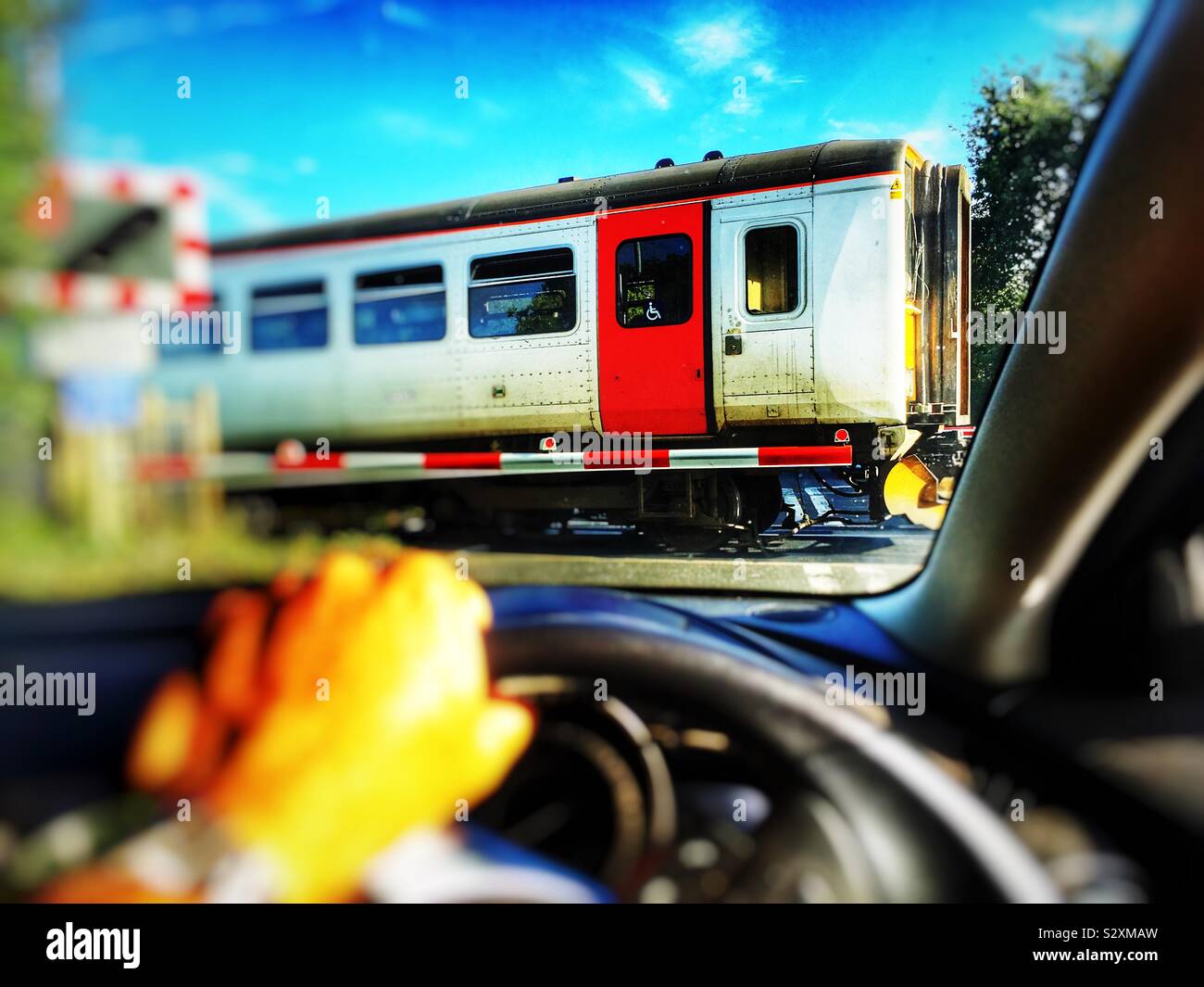 Treno locale che va oltre il passaggio a livello sulla East Suffolk linea di ramificazione a Melton. Foto Stock