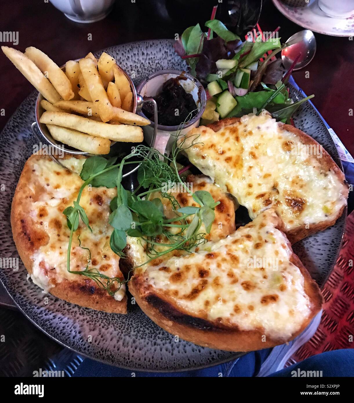 Welsh rarebit, Skinny Fries, insalata e chutney di cipolla Foto Stock