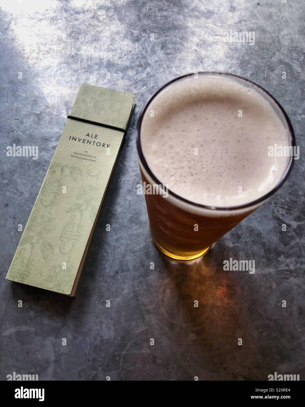 Guardando verso il basso sulla pinta di birra Ale e libretto di inventario. Foto Stock