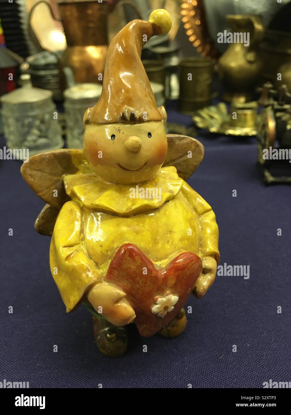 Ein kleiner Zwerg, Troll oder Elf Mit einem Herz in der mano. Foto Stock