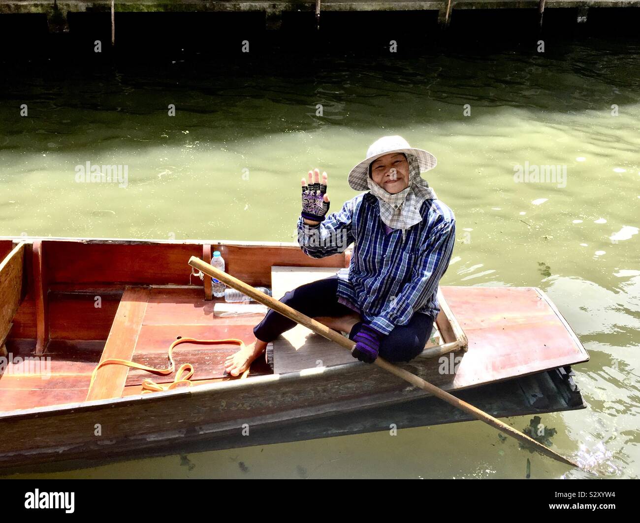 Una donna in barca al Mercato Galleggiante di Damnoen Saduak in Thailandia. Foto Stock