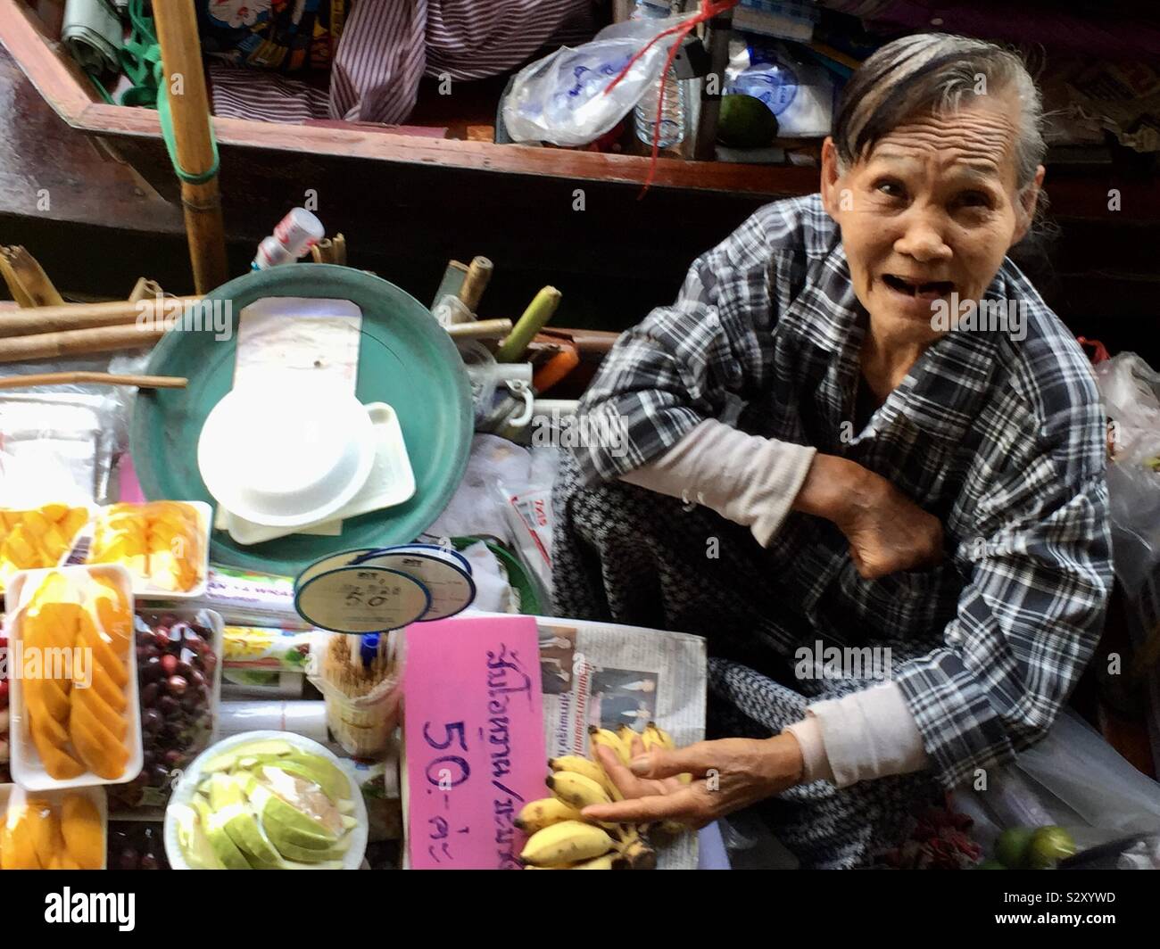 50 baht! Una donna venditore al Mercato Galleggiante di Damnoen Saduak. Foto Stock
